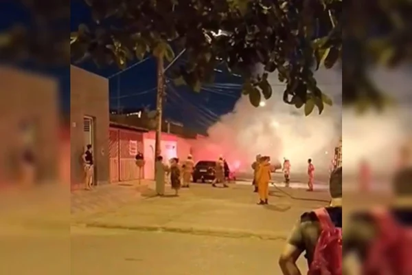 Foto colorida com fumaça no meio da rua e bombeiros