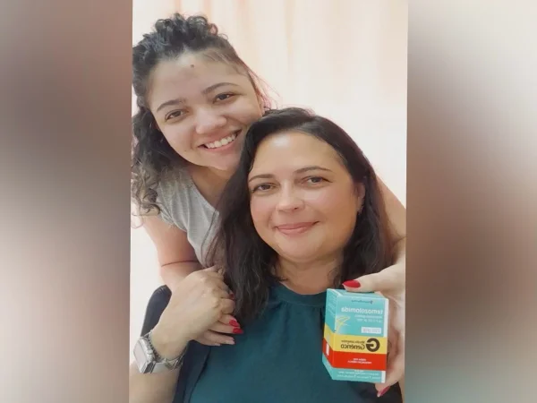 Mãe e filha com o medicamento Temozolamida em mãos