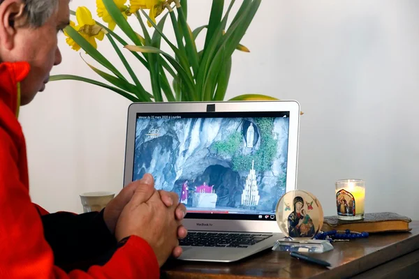 Homem rezando em frente ao computador