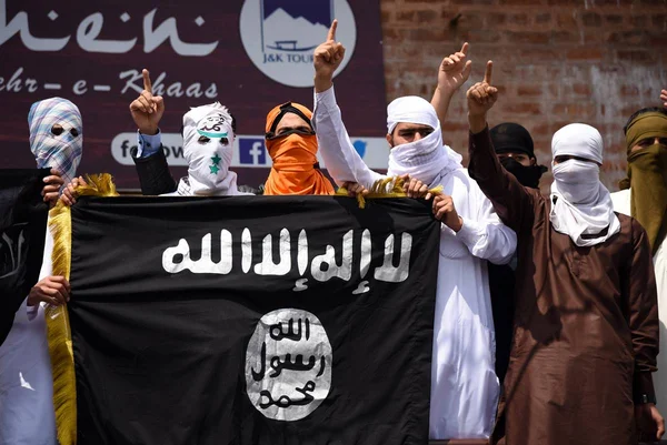 Imagem colorida mostra homens pró-Estado Islâmico segurando bandeira do grupo terrorista - Metrópoles