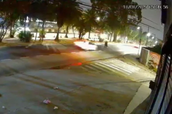 Imagem colorida de carro em alta velocidade se aproximando de mulher, que está no meio de uma avenida - Metrópoles