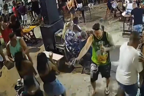 Foto colorida de homem atirando em outro