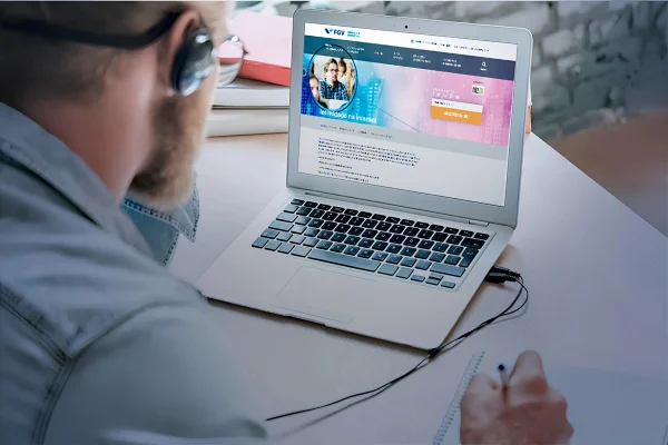 Imagem colorida de um homem mexendo olhando um computador - Metrópoles