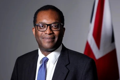 Kwasi Kwarteng, ministro das Finanças britânico, caiu após plano fiscal desastroso. Na foto ele usa terno e óculos, sorrindo para a câmera - Metrópoles