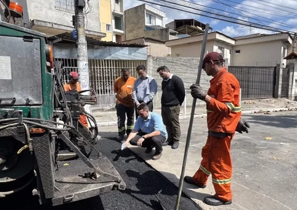 Imagem colorida mostra operários fazem o serviço de tapa-buraco - Metrópoles