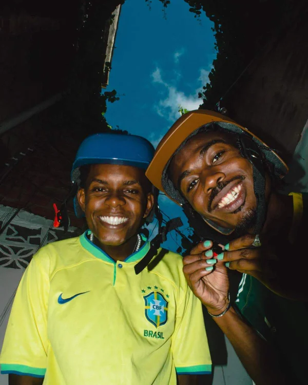 A imagem mostra dois rapazes de capacete