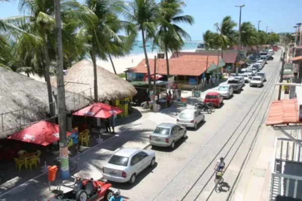 Imagens coloridas mostram visão do alto de rua de comércio à beira da praia