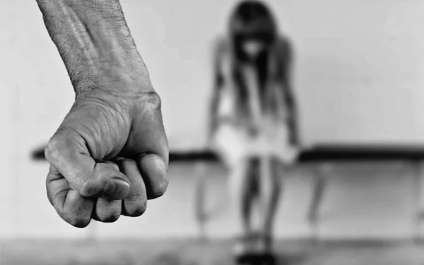 Homem fecha a mão enquanto criança de cabeça baixa demonstra medo
