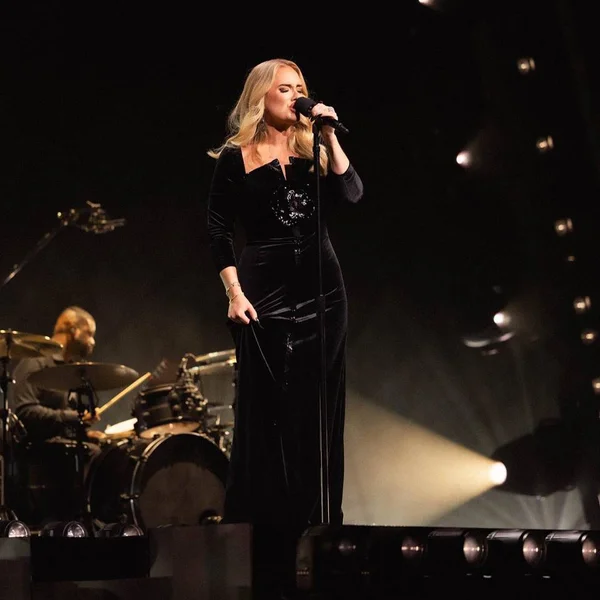 Foto colorida da cantora Adele performando em cima do palco - Metrópoles