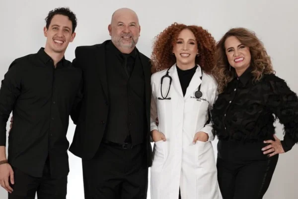 Foto colorida de dois homens e duas mulheres vestidos de preto, sorrindo para foto - Metrópoles
