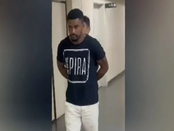 Foto colorida mostra suspeito preso