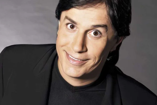Foto colorida de Tom Cavalcante vestido de preto e sorrindo - Metrópoles