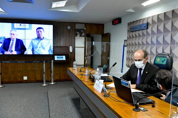 O prefeito Gilberto Braga, no telão da Comissão de Educação, e senador Marcelo Castro, presidente, na mesa diretora - Metrópoles