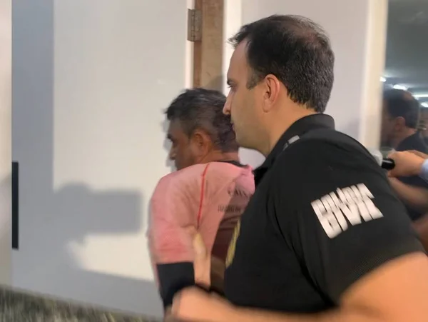 Horácio, segundo detido em operação que procura os criminosos responsáveis pela morte de uma família de seis pessoas e desparecimento de duas. Na imagem, o criminoso é conduzido por policial na Delegacia do Itapoã - Metrópoles