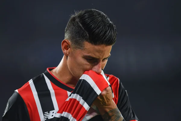 Imagem colorida de James Rodriguez com a camiseta no rosto - Metrópoles