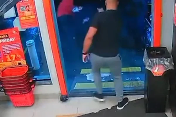 Imagem colorida de um homem atirando em outro pelas costas