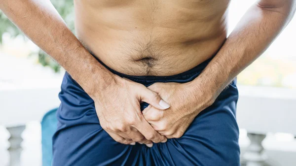 Foto mostra homem apertando o pênis e contorcido de dor. Close-up de um homem com as mãos segurando a virilha, conceito de infecção do trato urinário, síndrome da bexiga dolorosa e cistite intersticial - Metrópoles