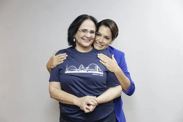 Fotografia colorida de duas mulheres que vestem azul