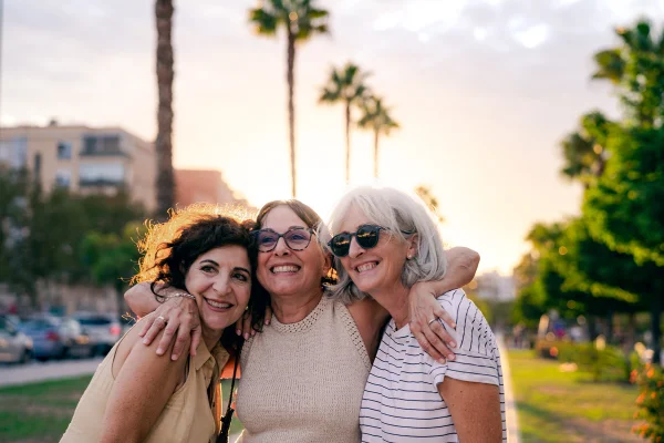 Imagem colorida mostra mulheres brancas se abraçando e sorrindo - Metrópoles