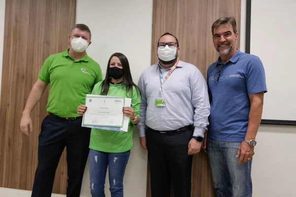 quatro homens e uma mulher segurando um diploma