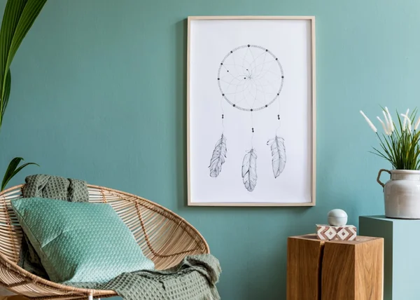 Foto de uma sala com parede verde e poltrona feita de palha com uma almofada verde