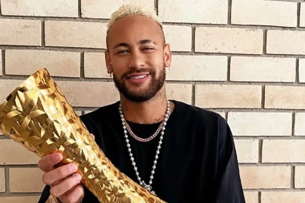 Imagem colorida: jogador Neymar segura troféu dourado - Metrópoles