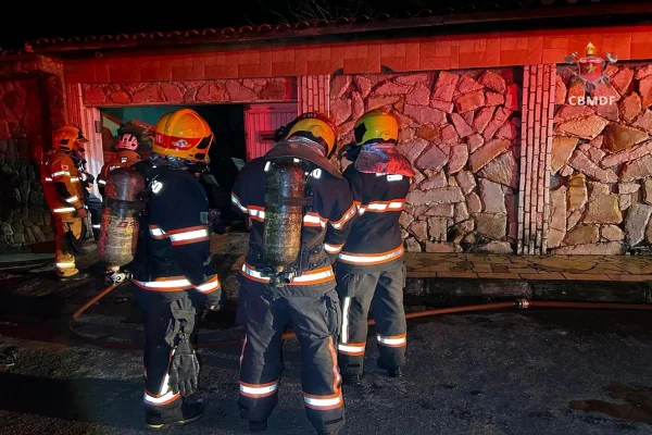 Foto colorida bombeiros militares combatendo a incêndio