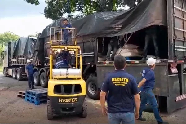 Homens retirando mercadorias de caminhão - Metrópoles