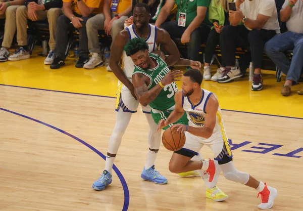 Marcus Smart, do Boston Celtics, entre Draymond Green e Stephen Curry, do Golden State Warriors