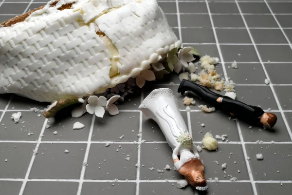bolo de casamento com dois noivinhos jogados no chão