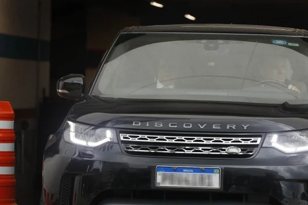 O governador afastado Ibaneis Rocha aparece sentado no banco de carona da frente de uma Land Rover preta após sair da Polícia Federal. Ele prestou depoimento sobre os ataques terroristas no DF de domingo - Metrópoles