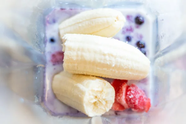 Imagem mostra um liquidificador com frutas vermelhas e pedaços de banana - Metrópoles
