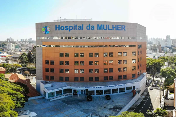Prédio de 8 andares de cor laranja e letreiro "hospital da mulher"