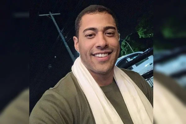 homem forte cabelo curto com blusa verde e cachecol branco