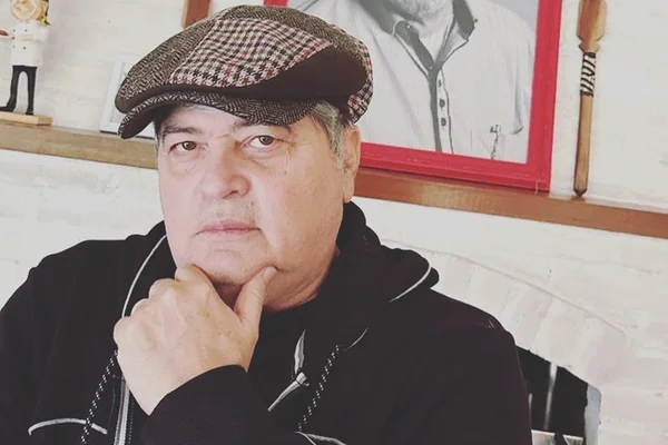 Datena posa de boina e com a mão no queixo- Metrópoles