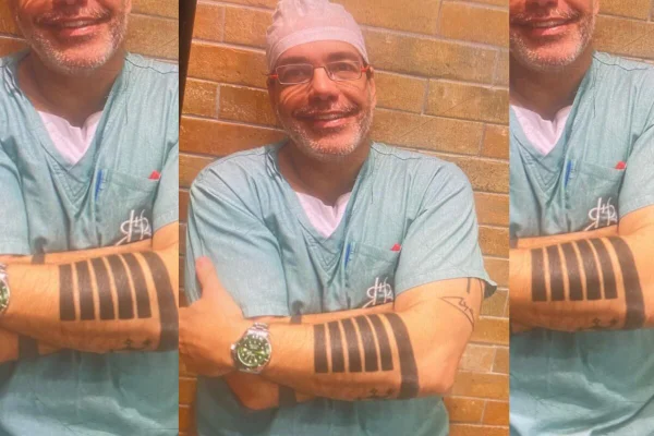 Médico com touca rosa e camiseta azul clara de cirurgião - Metrópoles