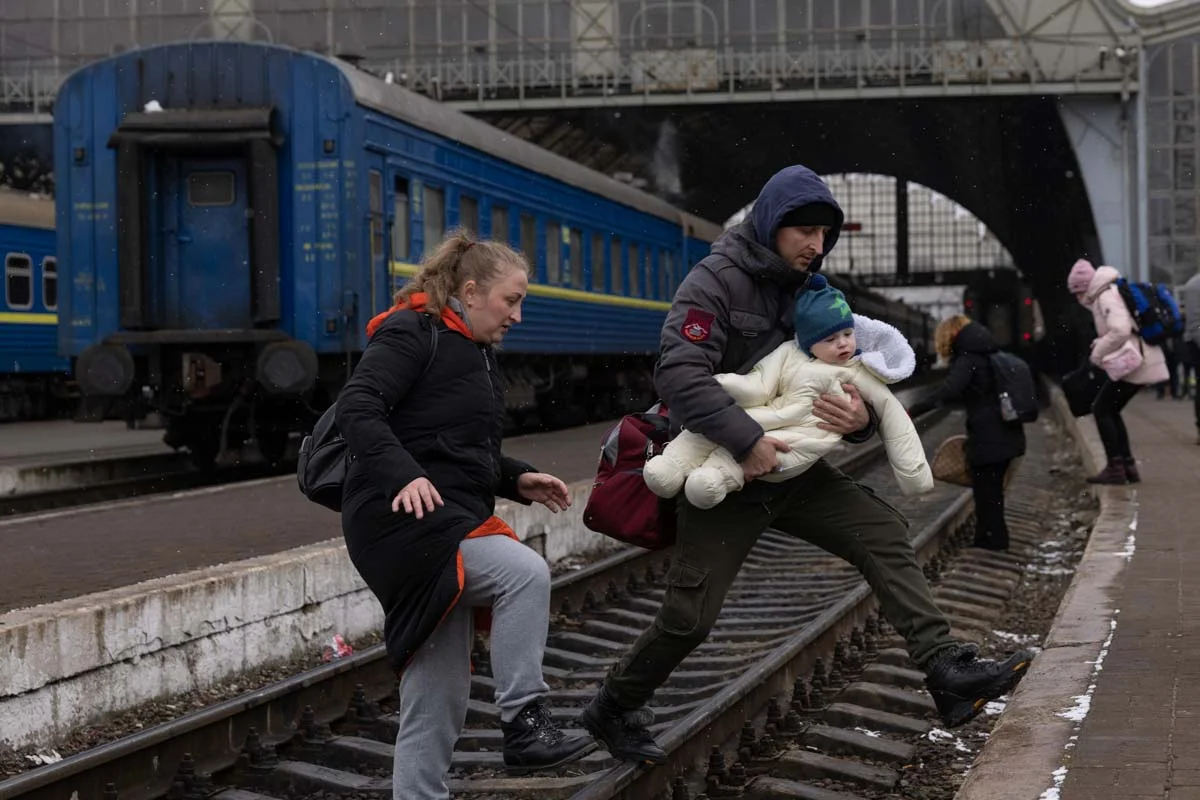 Uma família atravessa a linha férrea enquanto continua sua jornada no principal terminal de ônibus e trem em 05 de março de 2022 em Lviv, Ucrânia. Mais de um milhão de pessoas fugiram da Ucrânia após o ataque em larga escala da Rússia ao país, com centenas de milhares de ucranianos passando por Lviv a caminho da Polônia Uma família atravessa a linha férrea enquanto continua sua jornada no principal terminal de ônibus e trem em 05 de março de 2022 em Lviv, Ucrânia. Mais de um milhão de pessoas fugiram da Ucrânia após o ataque em larga escala da Rússia ao país, com centenas de milhares de ucranianos passando por Lviv a caminho da Polônia