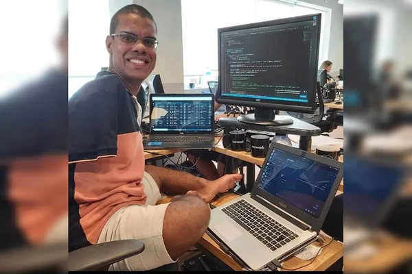 Homem usa seus pés para mexer no computador