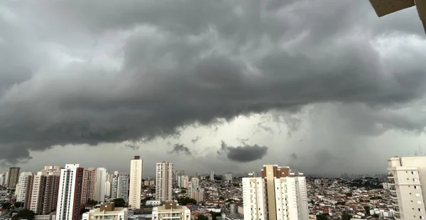 foto colorida com vista da cidade de são paulo, com vários prédios e nuvens carregadas sobre a capital