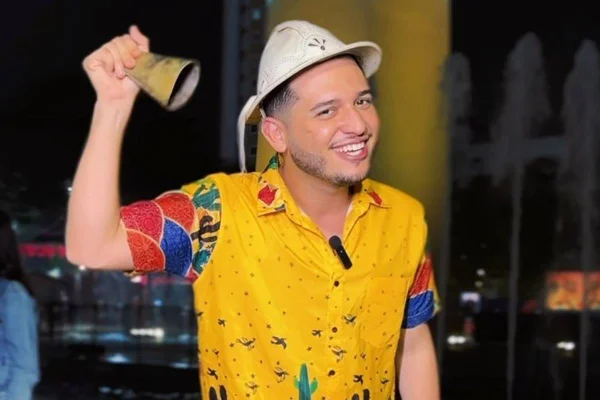 foto colorida de homem sorrindo com chapéu nordestino na cabeça e sino na mão - metrópoles