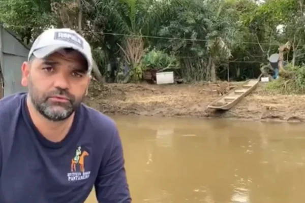 Imagem colorida de homem com uma onça pintada no fundo