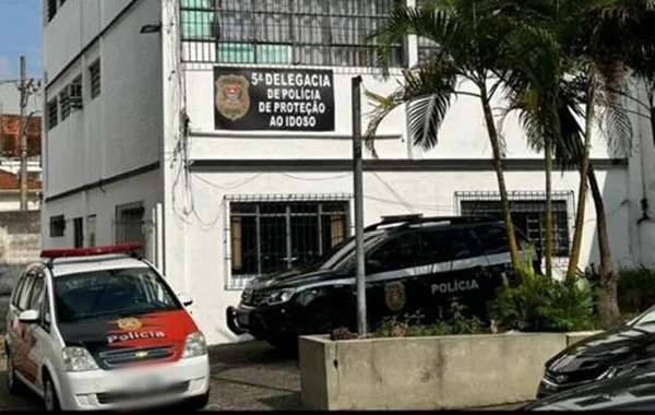 Foto colorida de fachada de delegacia do idoso, com viatura policial estacionada a frente - Metrópoles