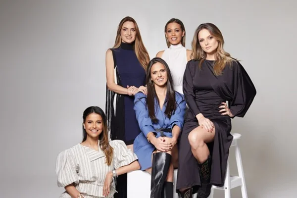 Na imagem com cor, mulheres da Dom de Vestir posam para as fotos