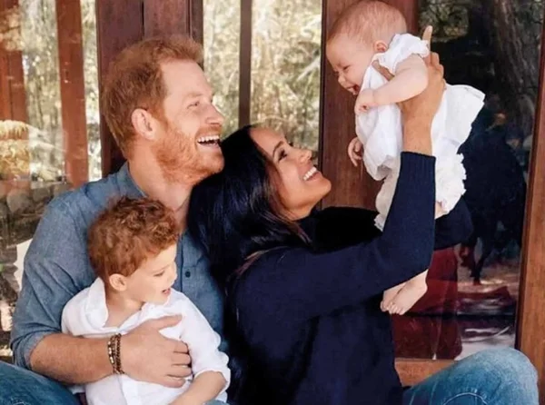 Harry, Meghan segurando os filhos
