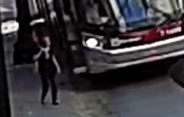 Imagem colorida mostra mulher andando perto de ônibus no centro de São Paulo - Metrópoles