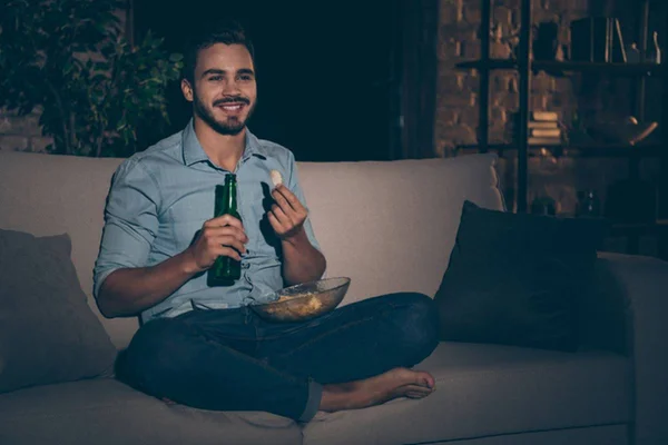 Imagem colorida de rapaz solteiro comendo batatas e cerveja - Metrópoles