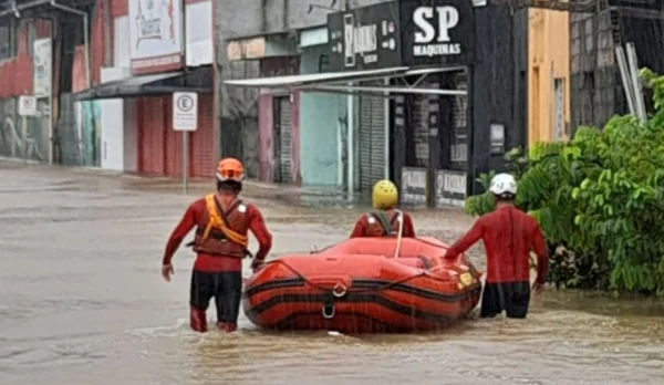 foto colorida de homens da Defesa Civil durante operação de resgate durante chuva em Ubatuba, no litoral norte de São Paulo - Metrópoles