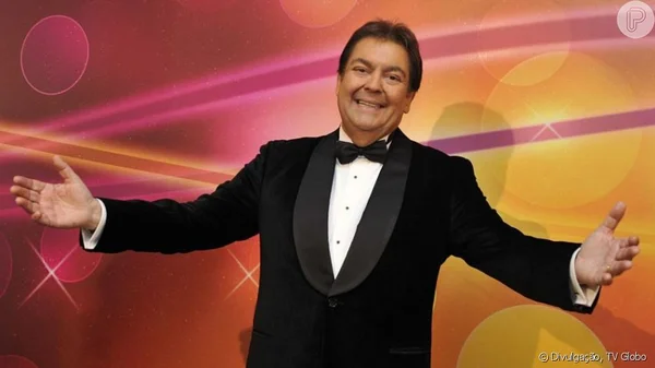 Foto colorida de Faustão com os braços abertos - Metrópoles