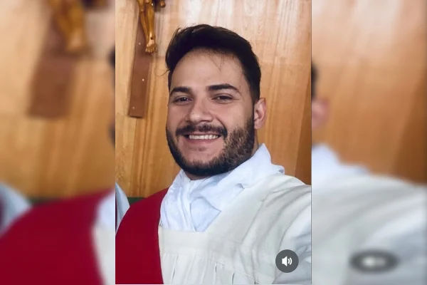 Imagem colorida de um homem usando bata branca com detalhes em vermelho