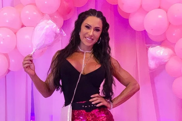 De microshort, Gracyanne senta no asfalto para aparecer em foto